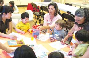 Volunteers work with children while their parents also participate in a Parenting Education class.