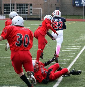 #23 Matt Weiler in “Beast Mode” running over the defenders on his way to one of many touchdowns in 2014. When Matt was not running for touchdowns, he was equally adept at throwing for touchdowns with the running back option pass play. Photo by Shari Fruhling 