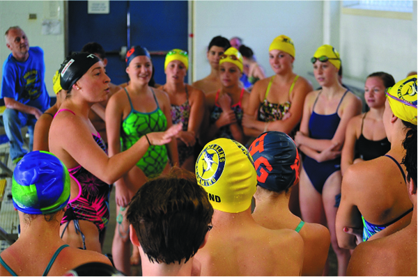 Ariana gives tips and advice to a rapt group of competitive young swim- mers at the Boys and Girls Club in Mount Kisco.