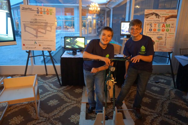Jason Lavender (right) and Nate Meyer, 6th graders at Seven Bridges Middle School, described the “bicycle generator” they designed. “The bicycle has a generator that powers a television through a battery, capacitor and inverter that connect to the television."