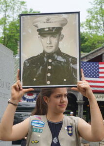 Meaghan Townsend holding a picture of Francis M. Murphy, Korean War Veteran, Silver Star Recipient. Meaghan, of Girl Scout Troop 1023, also read an oral history of Robert L. Sheddon, WWII Veteran.