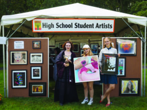 Byram Hills High School seniors (l to r) Juliana Zepf, a ceramicist and paper sculptor, Gabrielle Kleinberg, painter, and Allegra Samsen, photographer, hold up some of their art on display at the Armonk Outdoor Art Show outside a tent dedicated to the work of 24 student artists primarily from Armonk but also from surrounding towns, whose work was juried into the show, on September 24, 2016. Photo © 2016 Marianne A. Campolongo