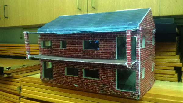 Model of a passive solar home with elements of sound, light, motion, and a sensor, designed and built by an Intro to Engineering student at Greeley.
