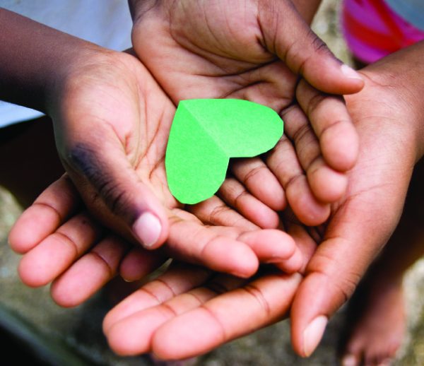 love; beautiful hands of children holding green heart shape
